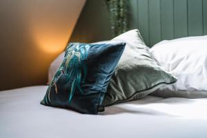 almohada azul en una cama con almohadas blancas en Otter's Pocket en Blandford Forum