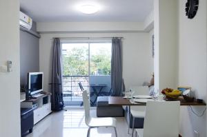 a living room with a table and a dining room at The September Salaya in Salaya