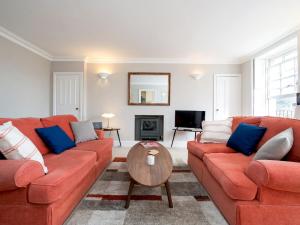 a living room with two orange couches and a table at Pass the Keys Lovely 1 bed flat with parking close to the centre in Bath