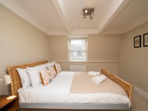 a bedroom with a bed with white sheets and a window at Pass the Keys Spacious 3 bed apartment in prime central location in Bath