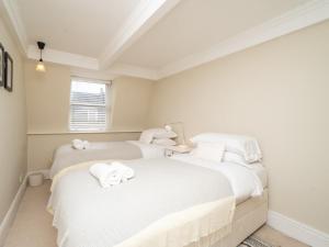 two beds in a room with white sheets at Pass the Keys Spacious 3 bed apartment in prime central location in Bath