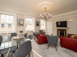 a living room with a glass table and chairs at Pass the Keys Spacious 3 bed apartment in prime central location in Bath