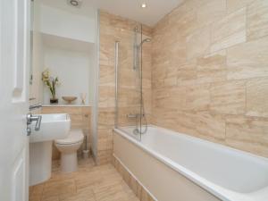 a bathroom with a tub and a toilet and a sink at Pass the Keys Spacious 3 bed apartment in prime central location in Bath
