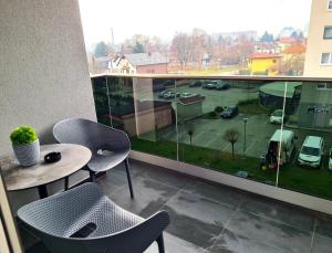 a balcony with a table and chairs and a view of a parking lot at Wellness Apartments in Varaždin