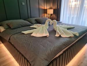 Una cama con toallas de cisne encima. en Wellness Apartments, en Varaždin