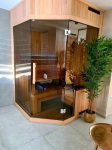 a large glass cabinet in a room with a potted plant at Wellness Apartments in Varaždin