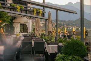 a restaurant with tables and umbrellas on a balcony at Hotel Tirolensis in Tesimo