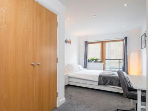 1 dormitorio con cama, escritorio y ventana en Pass the Keys Spacious 1 Bedroom Apartment in Heart of the City, en Cardiff