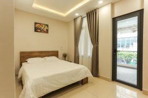 - une chambre avec un grand lit et une fenêtre dans l'établissement ĐồiSao Homestay, à Hô-Chi-Minh-Ville