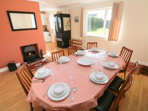 uma sala de jantar com uma mesa e cadeiras e uma lareira em Meadow View em Haverfordwest