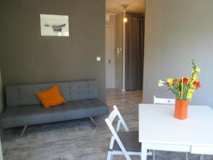 a living room with a couch and a table with flowers at Appartamento Ritz in Grado