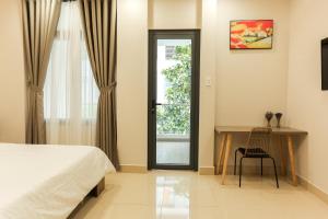 - une chambre avec un lit, une table et une fenêtre dans l'établissement ĐồiSao Homestay, à Hô-Chi-Minh-Ville