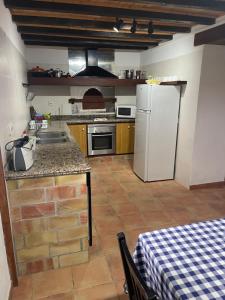 Una cocina con un refrigerador blanco y una mesa. en Can Joan Barber, 1, en La Mola