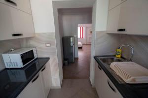 a kitchen with a sink and a microwave on a counter at Apartman Oliver in Novigrad Istria
