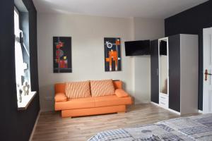 ein Wohnzimmer mit einem orangenen Sofa in einem Zimmer in der Unterkunft Ferienwohnung Wolf in Havelberg