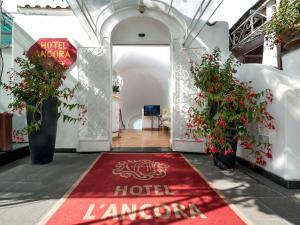a hotel lobby with a red carpet and flowers at Hotel L'Ancora in Positano