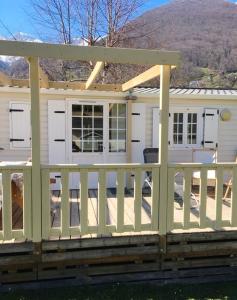 a porch with a white fence and a house at Bungalow de 2 chambres a Cauterets a 900 m des pistes avec jardin amenage et wifi in Cauterets