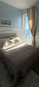 Un dormitorio con una cama grande y una ventana en B&B DaGiueli, en Alassio