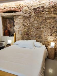 een slaapkamer met een bed in een stenen muur bij Casa da Sé Cathedral Suites in Coimbra