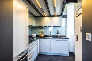 a kitchen with blue cabinets and a ceiling at Promo Easy Clés- Loft Port Vieux beach Parking in Biarritz