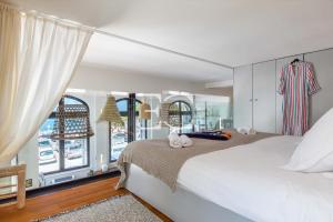 um quarto com uma cama branca e uma grande janela em Promo Easy Clés- Loft Port Vieux beach Parking em Biarritz