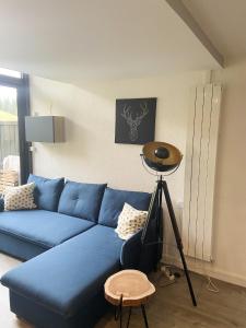 un divano blu in un soggiorno con un tavolo di Appartement cosy à Manigod avec piscine partagée – 50 m² a Manigod