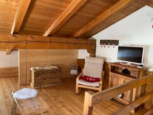 Cette chambre dispose d'une télévision, d'une chaise et d'un bureau. dans l'établissement Coeur de montagne, à Gignod
