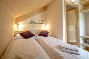 Un pat sau paturi într-o cameră la Kreischberg Chalets by ALPS RESORTS