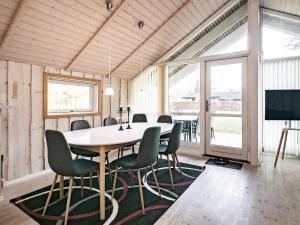 a dining room with a table and chairs at Holiday home Asaa V in Aså