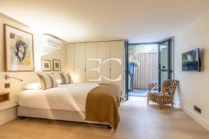 sypialnia z łóżkiem i przesuwnymi szklanymi drzwiami w obiekcie Promo Easy Clés-Loft spirit house 500m beach AC w Biarritz