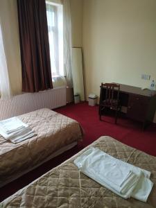 a hotel room with two beds and a desk at Hostel One in Lankaran