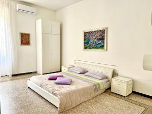 a bedroom with a white bed with purple pillows at Casa Vacanze Sunshine in Salerno