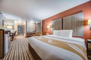 a hotel room with a large bed and a desk at Quality Inn Hastings in Hastings