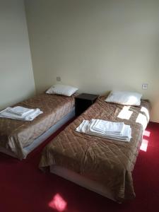 two beds in a hotel room with towels on them at Hostel One in Lankaran