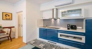 a kitchen with blue cabinets and a sink at Best Western Plus Celebrity Suites in Vienna