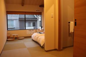 una camera da letto con un letto e una grande finestra di 城崎温泉 小宿 紬 tsumugi a Toyooka