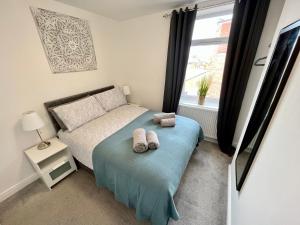1 dormitorio con 1 cama con 2 toallas en Apartments @52 en Bridlington