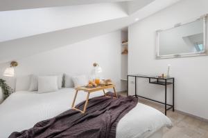 een witte slaapkamer met een bed met een tafel erop bij Bella Ciao Apartments in Rijeka