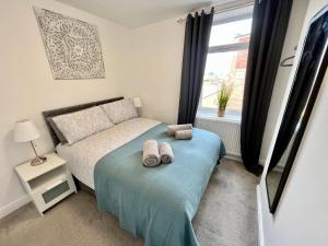 a bedroom with a bed with two towels on it at Apartments @52 in Bridlington