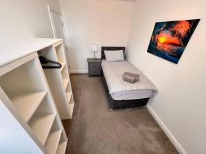 a small bedroom with a bed and a painting on the wall at Apartments @52 in Bridlington