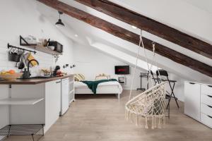 a kitchen with white cabinets and a hanging chair at Bella Ciao Apartments in Rijeka