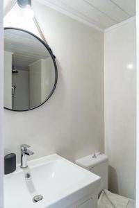 La salle de bains est pourvue d'un lavabo blanc et d'un miroir. dans l'établissement Quattro Domus 2 townhouse, à Héraklion