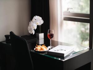 a table with a glass of wine and a plate of food at JW Marriott Hotel & Suites Saigon, The Apartments in Ho Chi Minh City +70 photos