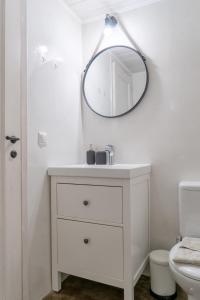 La salle de bains blanche est pourvue d'un lavabo et d'un miroir. dans l'établissement Quattro Domus 2 townhouse, à Héraklion
