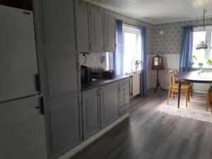 a kitchen with white cabinets and a table in a room at Hus på landet nära sjö in Berga +7 photos