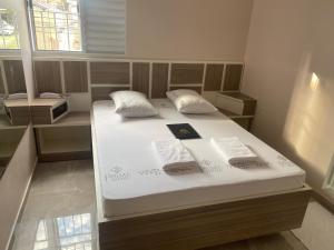 1 cama grande con sábanas blancas y almohadas. en Hotel Prime Tatuapé, en São Paulo