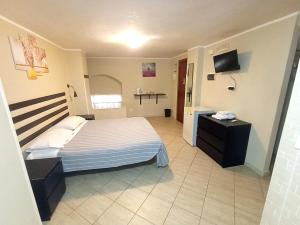 a bedroom with a bed and a television in it at Guest House Albergabici La Cattedrale in Barletta