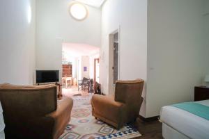 a bedroom with two chairs and a bed and a television at Kochab Sintra by LovelyStay in Sintra