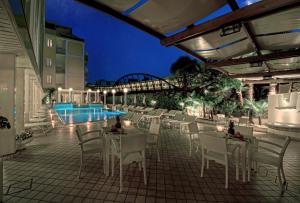 アーバノ・テルメにあるHotel Aurora Termeのパティオ(テーブル、椅子付)、プールが備わります。