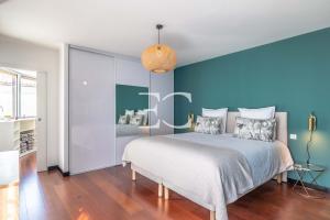 1 dormitorio con 1 cama con pared azul en PROMO Easy Clés- Lovely Villa 10p Heated Pool, en Arcangues